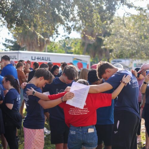 Family praying feed the block Love Serves Feed The Block HomesUnited Ministries (5)