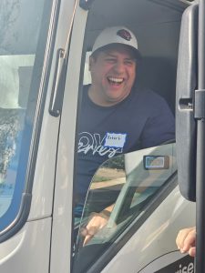 feed the block truck driver smiling handing out turkeys