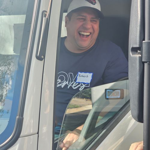 feed the block truck driver smiling handing out turkeys